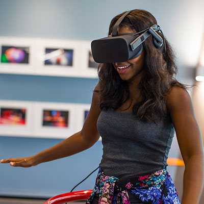 Student smiles while standing and wearing VR headset
