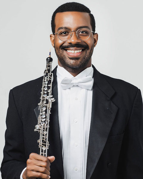 Headshot of Titus Underwood in a tux holding his oboe